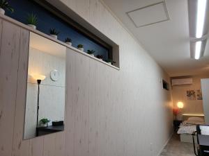 a room with a wall with a window and some plants at Greci Art Tokyo-Kinshicho Area Private room- in Tokyo +61 photos