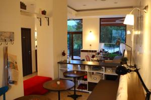 ein Wohnzimmer mit Tischen und Stühlen sowie eine Küche in der Unterkunft Hotel Par Avion in Aprilzi