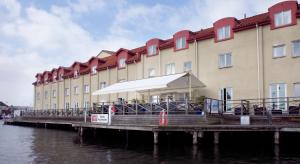 a building on a pier next to the water at Clarion Collection Hotel Packhuset in Kalmar