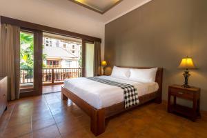 a bedroom with a bed and a large window at Vidi Boutique Hotel in Nusa Dua