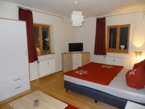 ein Schlafzimmer mit einem Bett mit einer roten Decke darauf in der Unterkunft Haus Kunterbunt in Reichenberg