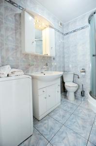 Baño blanco con lavabo y aseo en Apartament Morski en Kołobrzeg