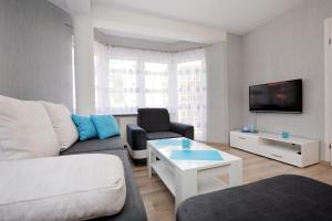 uma sala de estar com um sofá e uma mesa em Apartament Morski em Kolobrzeg