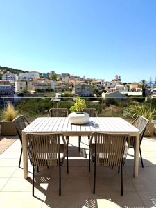 a white table and chairs on a patio with a view at Agia marina elaia luxury villa in Nea Kydonia