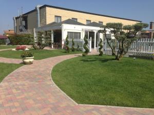 a house with a brick walkway in front of a yard at Hotel Bussana in Tolle