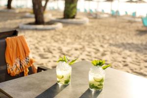 two drinks sitting on a table at the beach at Thassos Imperial Resort in Skala Rachoniou