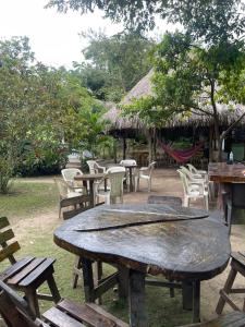 a large wooden table with chairs and tables at Zirumake Hostel Dentro del Parque Tayrona in El Zaino