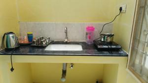 a kitchen counter with a sink in a room at Magizh Kudil in Pūrnānkuppam