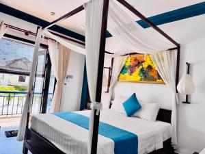 une chambre avec un lit à baldaquin et une fenêtre dans l'établissement Relax Garden Boutique Villa Hoi An, à Hội An 152 autres photos