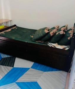 a bed with green sheets and pillows in a room at JAM'S STAYcation at Vinia Residences in Manila