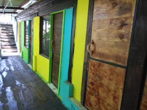 Cette chambre dispose d'une porte et d'un mur jaune et vert. dans l'établissement Colors Hostal, à Boquete