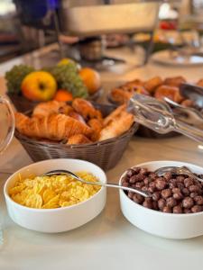 a table with bowls of food and baskets of bread at Licorna La Vie in Gura Vadului