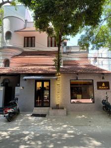 un edificio con un árbol delante en Reliable Nest, en Chennai