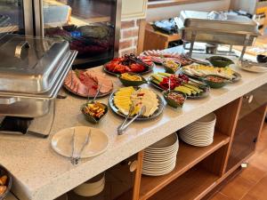 a buffet with many plates of food on a counter at Licorna La Vie in Gura Vadului