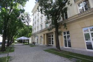 a large white building with trees in front of it at Dom Pomocy Studentom in Warsaw
