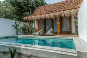 a swimming pool in front of a house at Romantic private villas Bayrin private villas in Nusa Penida
