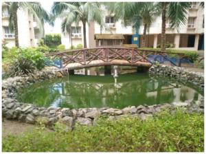a wooden bridge over a pond in a park at Hotel Santosh Classic Residency হোটেল সন্তোষ ক্লাসিক রেসিডেন্সি Puri - Lift, Parking, Swimming Pool & Spacious AC Rooms in Puri