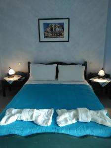 a blue bed with two white towels on it at Daira Apartments in Diakofti +20 photos