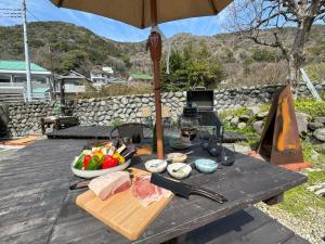 a picnic table with a bowl of food and an umbrella at TAKUMI-AN Private Ancient House and Garden in Numazu