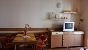 a dining room with a table and a tv at Apartmán Arsinoe in Oščadnica