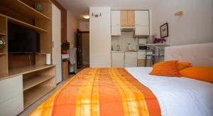 um quarto com uma cama grande com um cobertor laranja e amarelo em Apartment Nina em Split