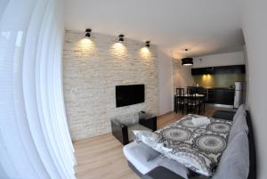 salon z kanapą i ceglaną ścianą w obiekcie Royal Apartments - Apartamenty Inowrocławska we Wrocławiu