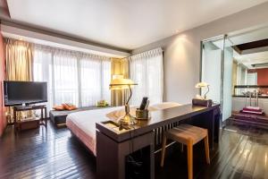 Dormitorio con cama, escritorio y TV en Loogchoob Homestay, en Bangkok