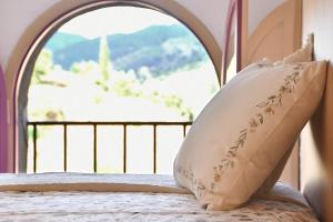 a pillow on a bed in front of a window at La Caseta del Priorat III in Porrera