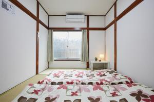 a bedroom with a large bed with a floral bedspread at Sweet House東池袋 in Tokyo +93 photos
