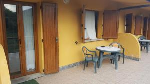 a small table and chairs next to a yellow wall at La Vallata in Rovieto