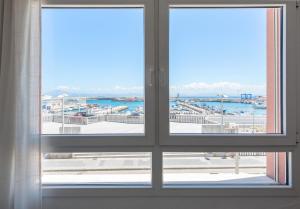 ein offenes Fenster mit Blick auf den Yachthafen in der Unterkunft Apartamento El Puerto Bahía in Tarifa