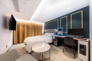 Una habitación de hotel con una cama y un escritorio con una computadora. en Jongro HOTEL LABOUM, en Seúl
