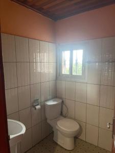 a bathroom with a toilet and a sink and a window at Complexe la samaritaine in Yaoundé