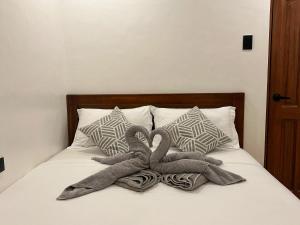 a bed with two stuffed animals laying on it at La Luna Inn El Nido in El Nido
