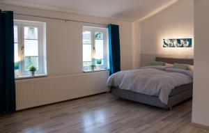 a bedroom with a bed and two windows at Ferienhaus Brauner Hirsch in Celle