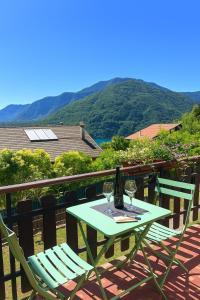 a table with two glasses of wine on a balcony at Villa Carla - Bosco in Ledro