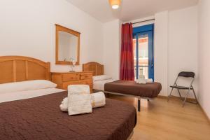 a hotel room with two beds and a window at Apartamento Castillejos in Tarifa