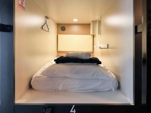 a bed in a small room with a white bedvisor at Bishop Hostel in Dallas +23 photos