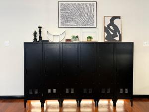a black dresser in a room with a wall at Bishop Hostel in Dallas