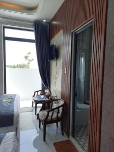 1 dormitorio con cama, mesa y baño en Khách sạn Nghìn Lẻ Một Đêm, 