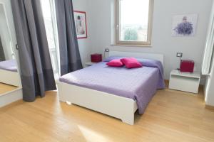 una camera da letto con un letto con due cuscini rosa di La Suite Sul Lago a Capodimonte