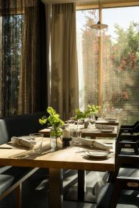 a wooden table with plates and glasses and a window at Bader Hotel in Parsdorf