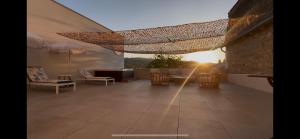 a living room with a table and chairs and the sunset at Hôtel égide in Espalion