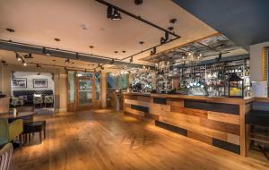 a bar in a restaurant with a wooden counter at The Kings Head Hotel, Richmond, North Yorkshire - The Coaching Inn Group in Richmond