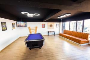 ナイロビにあるCozy Stylish Apartment with King Bed and Wi-Fiの卓球台とソファが備わる客室です。