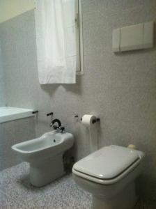 een witte badkamer met een toilet en een wastafel bij Cà Mea in Imperia