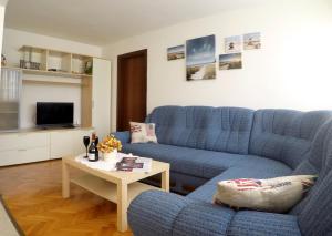 a living room with a blue couch and a table at Apartment Pizzybondo in Split