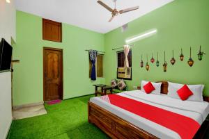 a bedroom with a bed and green walls at Hotel O Monalisa Guest House in Bhubaneshwar