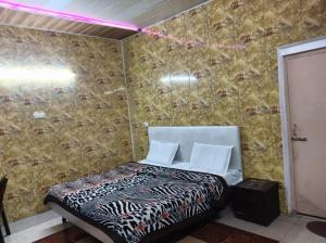 a bedroom with a bed with a wall covered in wallpaper at Aagman Homestay & Rooftop Restaurant in Mussoorie
