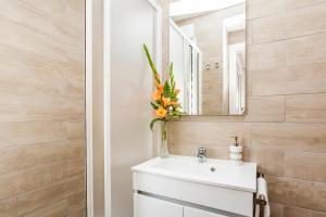 ein Badezimmer mit einem weißen Waschbecken und einem Spiegel in der Unterkunft Calado Apartments in Lissabon + 64 Fotos